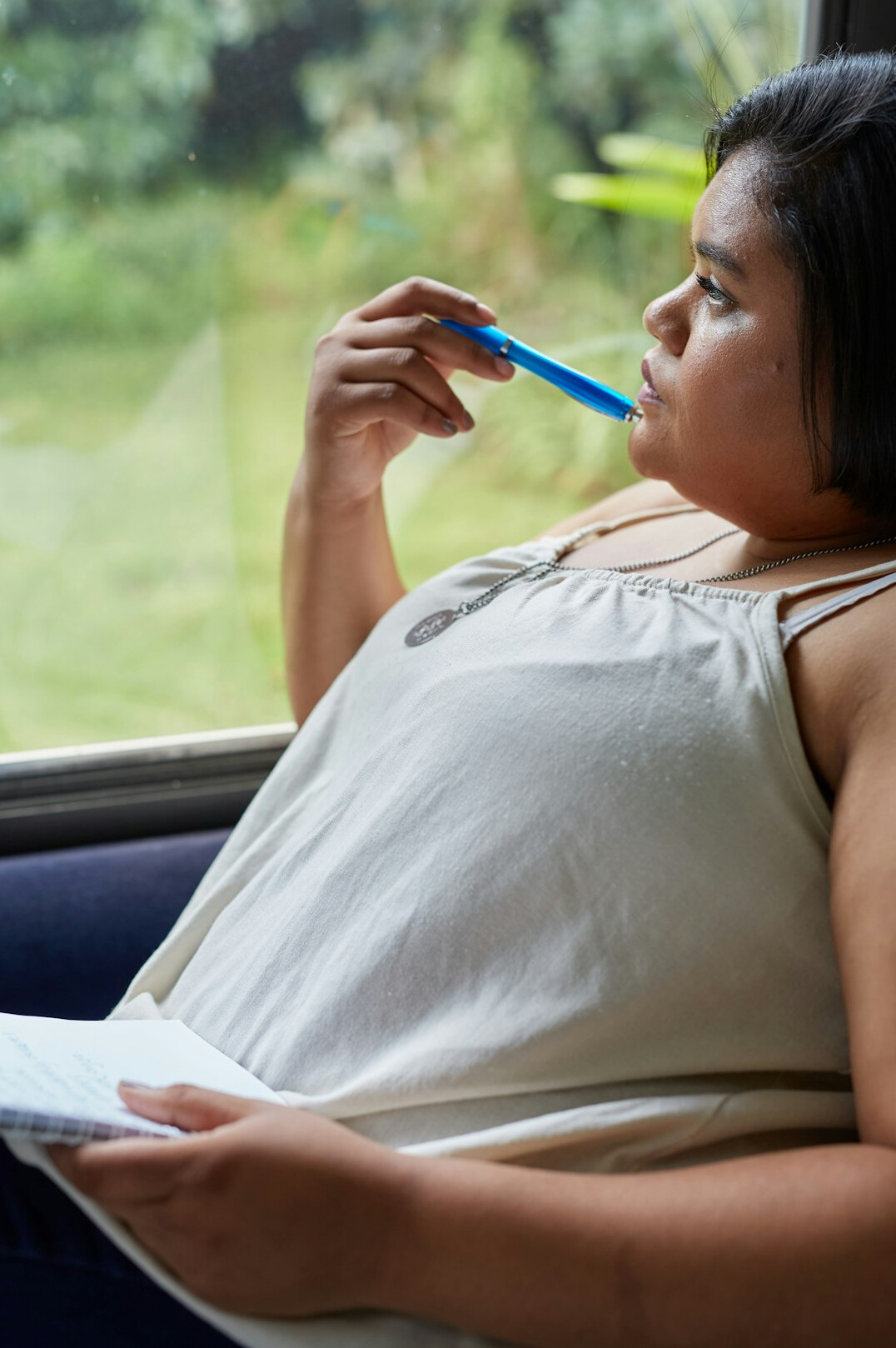 Brazilian woman writing thoughtfully in a journal